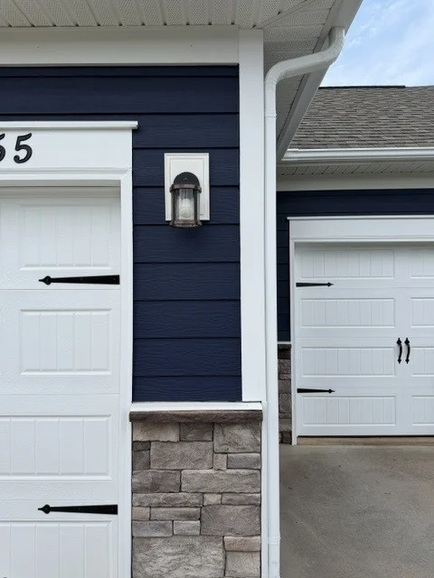 Residential exterior painting by Color World Painting on a Denver home featuring navy blue siding with white garage trim
