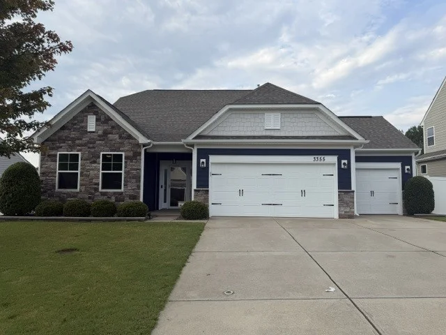Newly painted dark navy blue siding on a single-story home by Color World Painting in Denver featuring a landscaped front yard