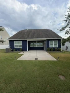 Rear exterior of a single-story home featuring dark navy blue siding painted by Color World Painting in Denver